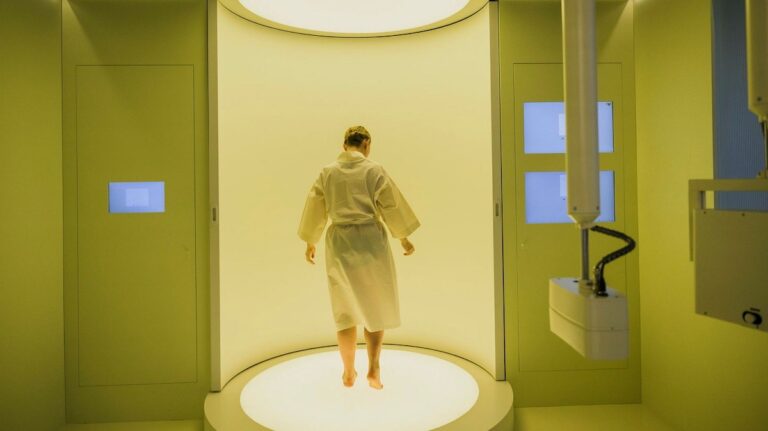 Man wearing a robe inside a full-body scan at Neko Health