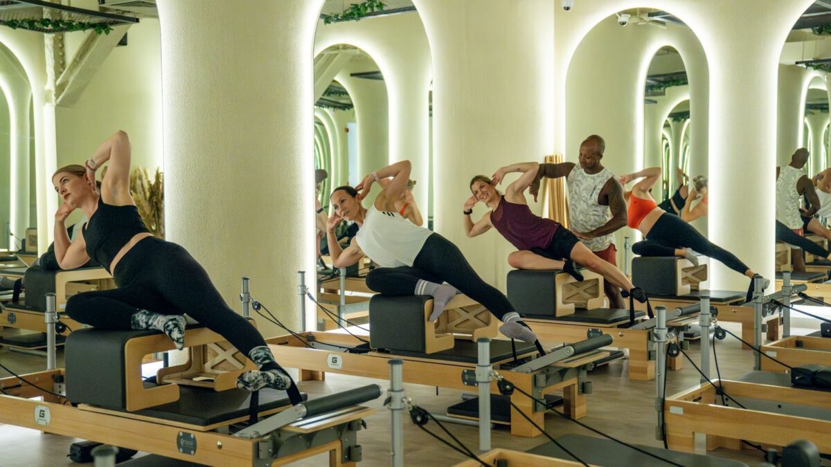 Group of four people doing reformer pilates