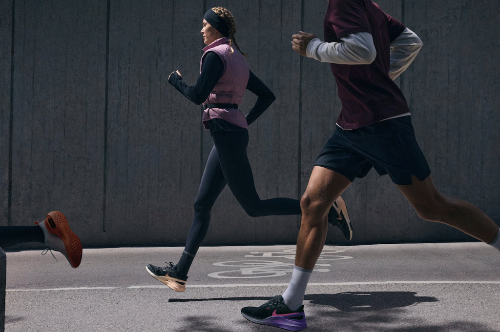Two people running side by side in Nike sneakers