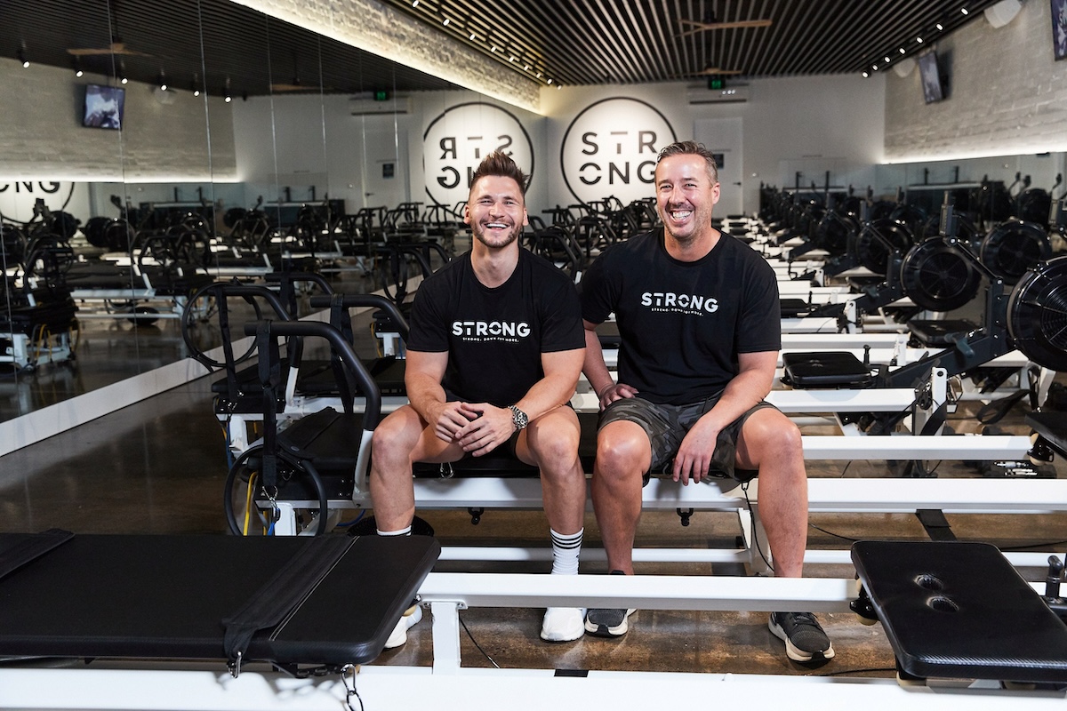 Co-Founders, Michael Ramsey & Mark Armstrong, sitting next to each other on a reformer
