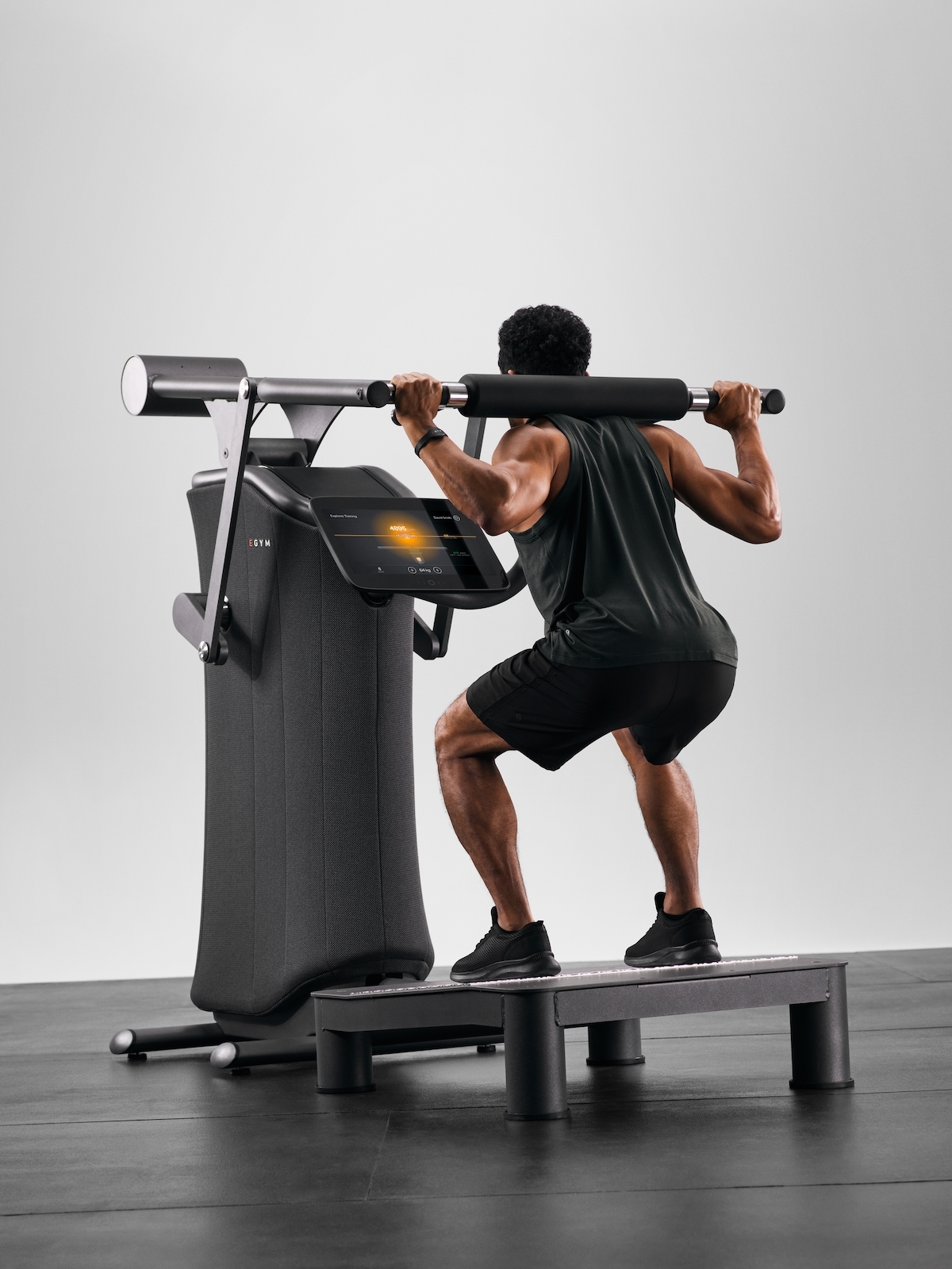 A man performing a squat using a fitness machine