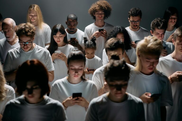 Group of people looking down at their cell phones