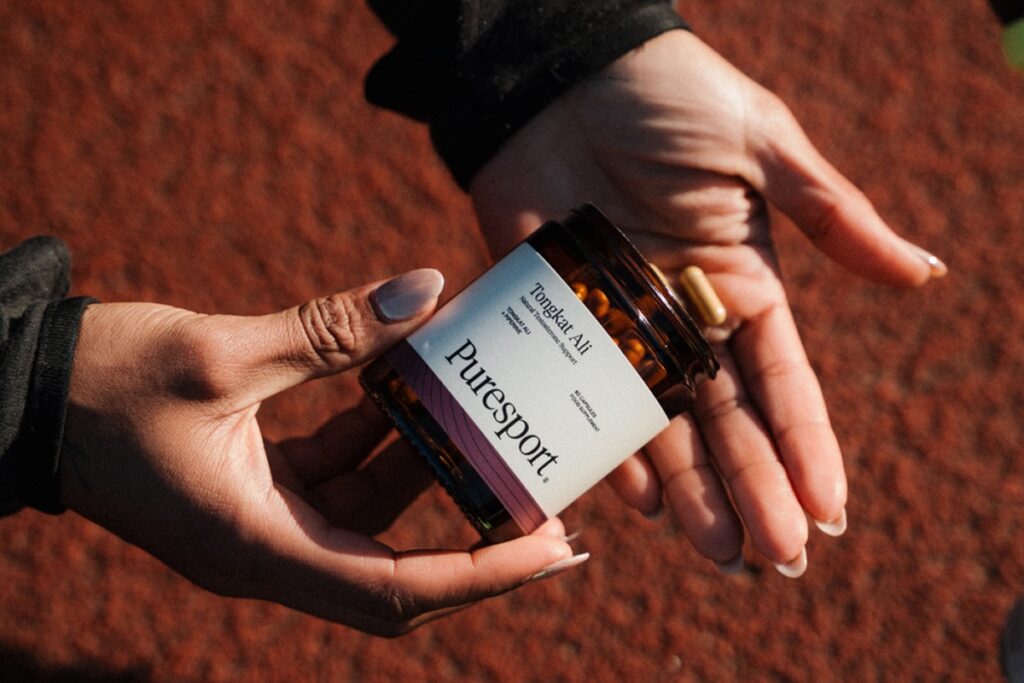 Holding a container of Puresport Tongkat Ali supplements