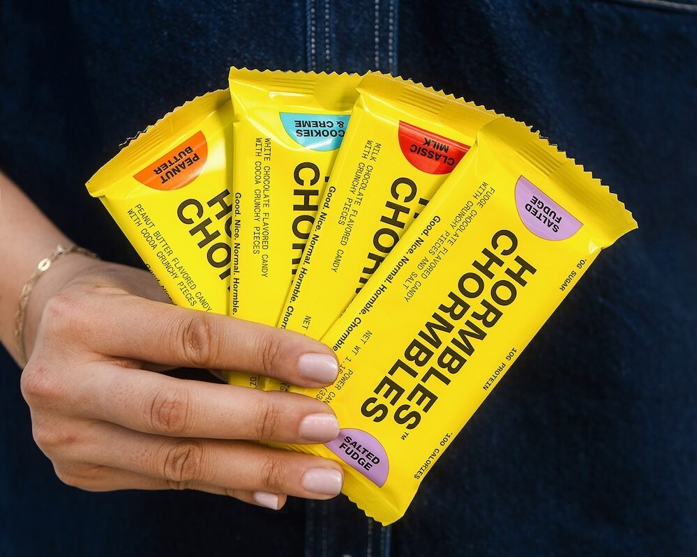 A hand holding assorted flavors of Hormbles Chormbles bars