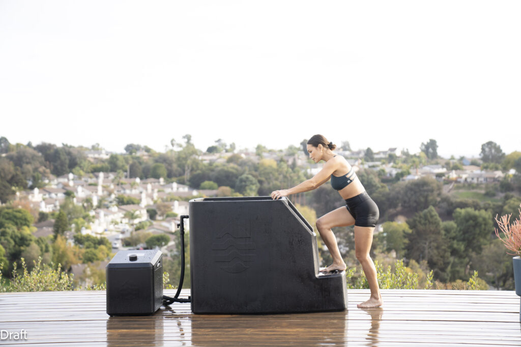 A woman is going into an ice bath outdoors