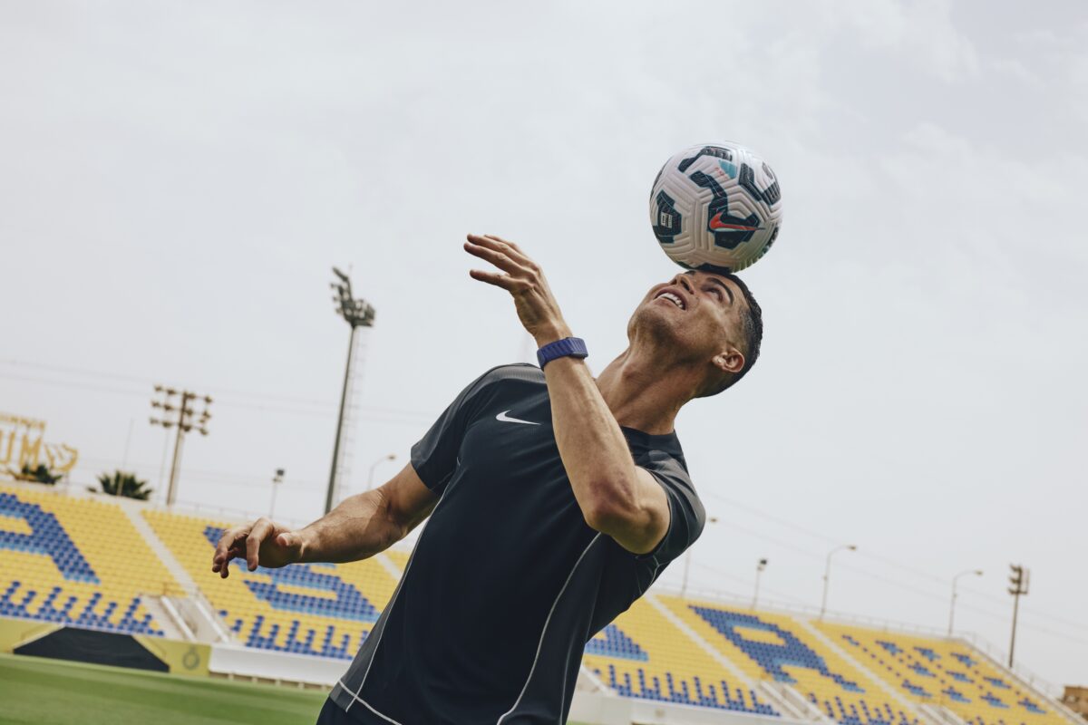 A soccer player balancing a soccer ball on his forehead