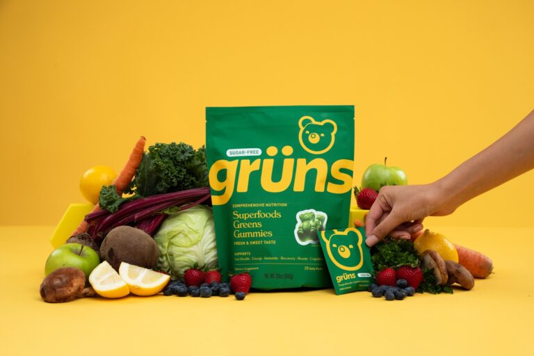A pack of Grüns Gummies surrounded by produce