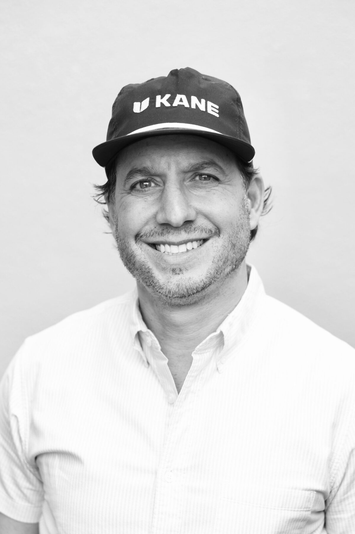Black and white headshot of Mark Tarnuzzer, Chief Marketing Officer at KANE Footwear