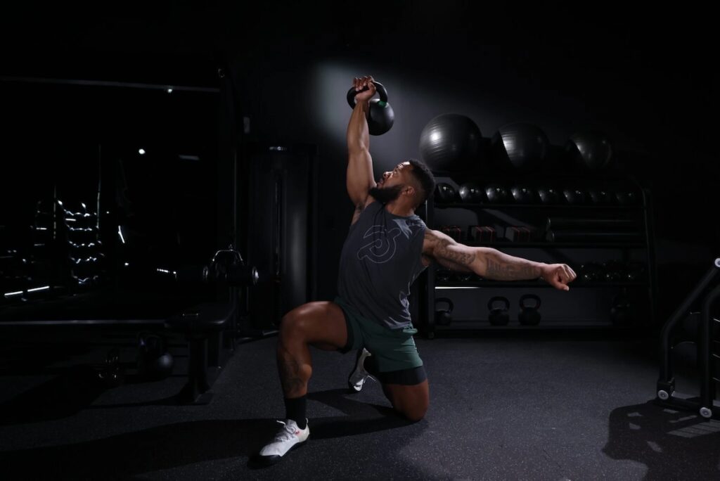 A fit man performing a kettlebell exercise