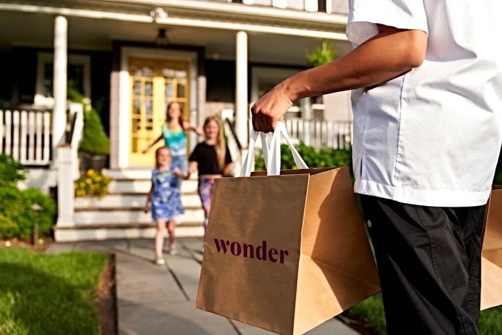 Man carrying a Wonder bag of food to his family
