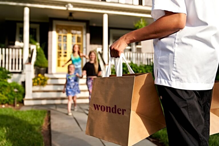 Man carrying a Wonder bag of food to his family