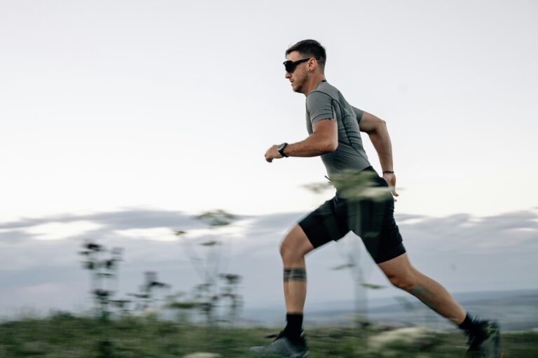 A man with sunglasses on running outside