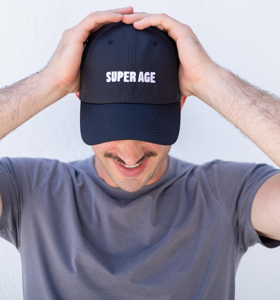 A man wearing a Super Age hat