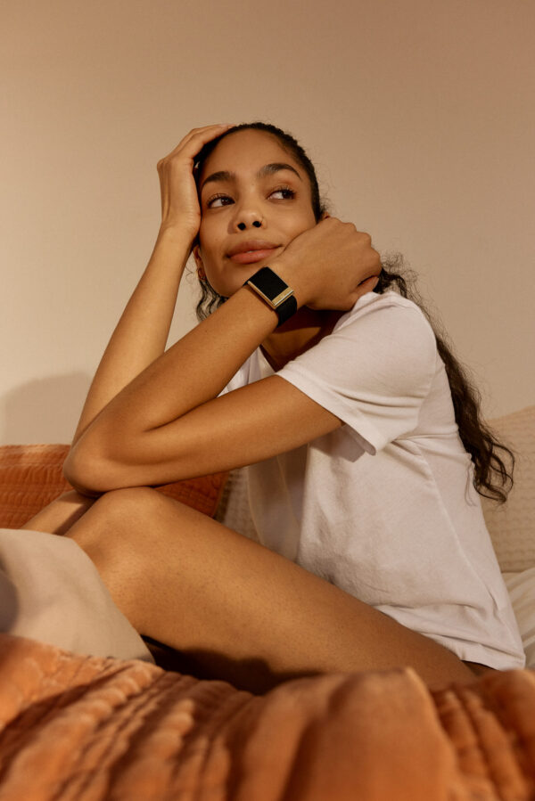 A woman in loungewear with a WHOOP band on her wrist