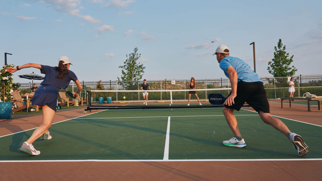 Two people playing pickleball outdoors