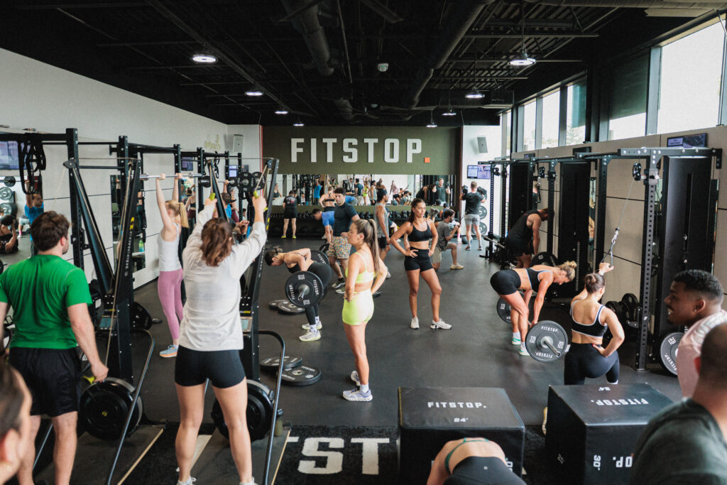 Group of exercisers in a Fitstop weight room.