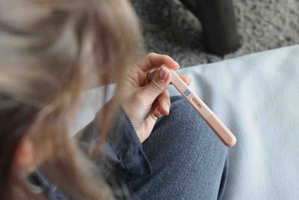 A woman looking at results on a pregnancy-like stick test