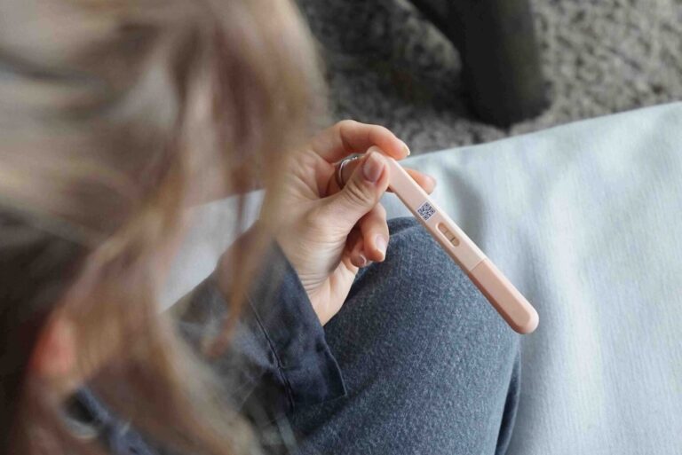 A woman looking at results on a pregnancy-like stick test