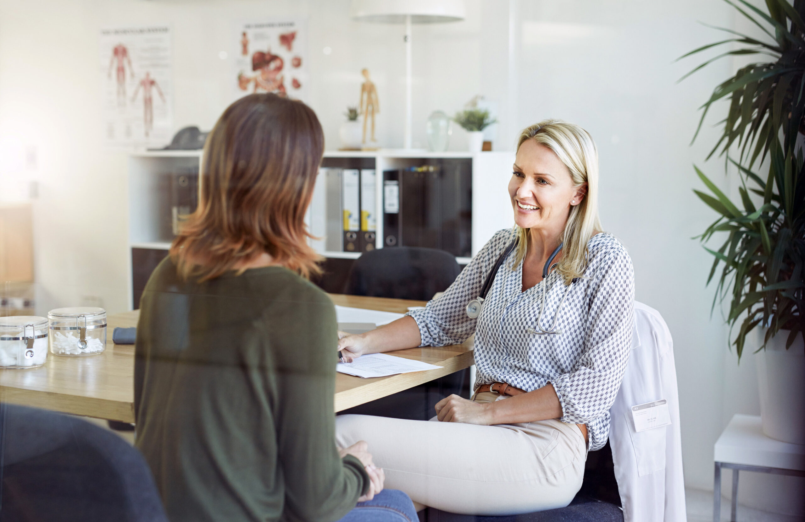 Two women sitting in an office and speaking with each other