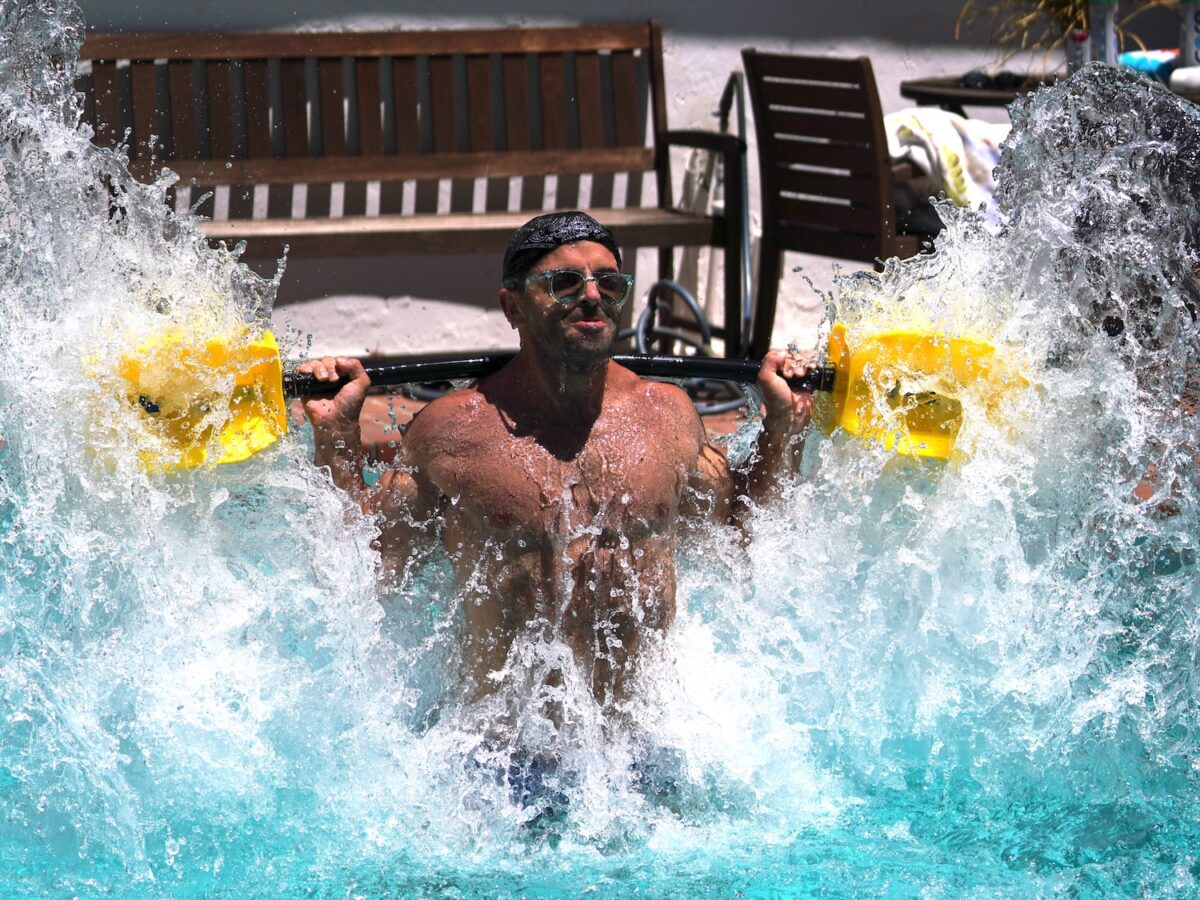 A man using a hydro dumbbell in a pool