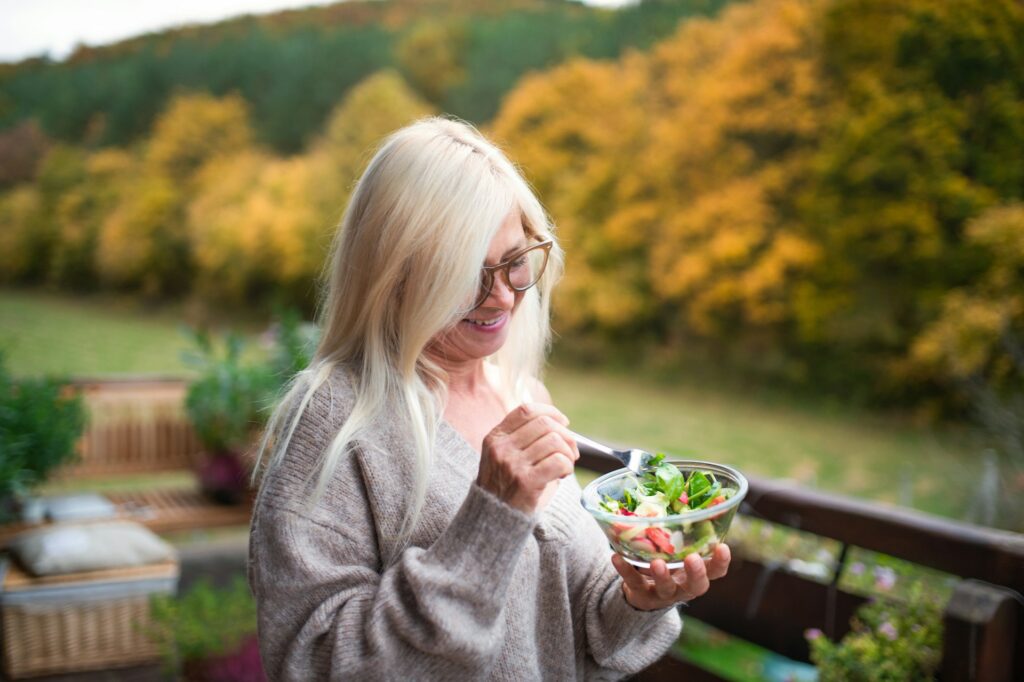 An older woman eating a salad
