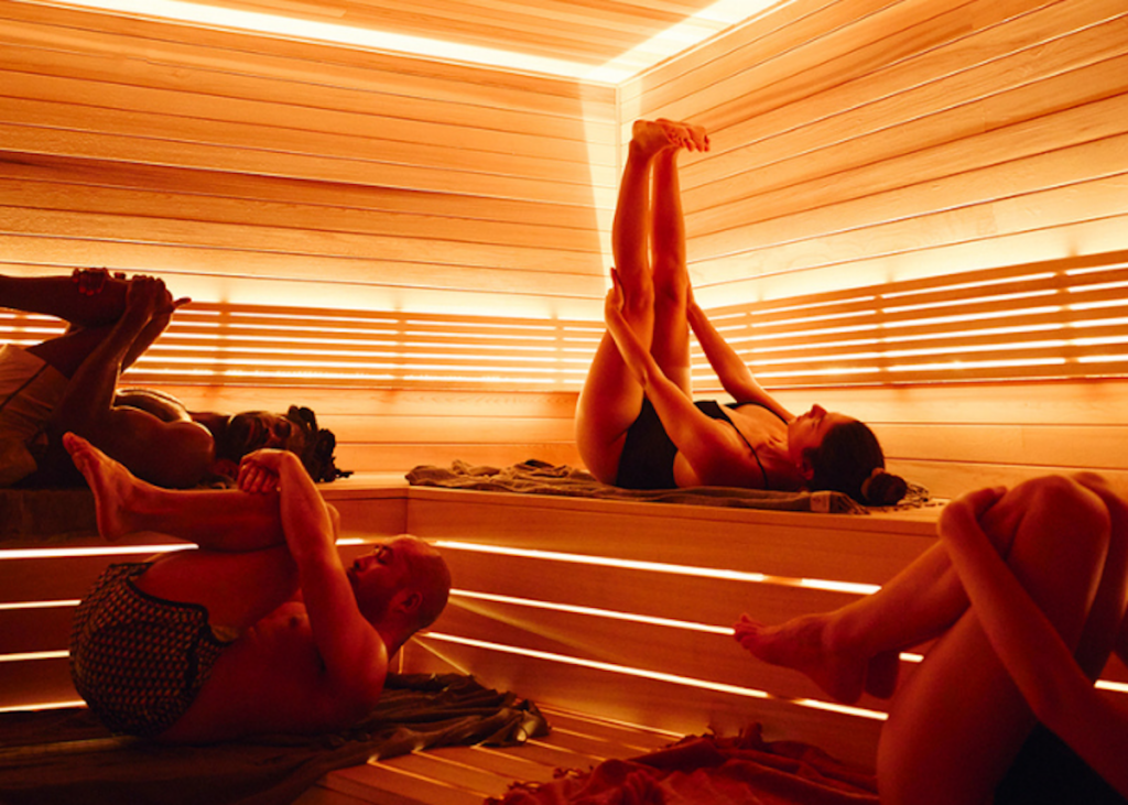 Group of people stretching in a sauna