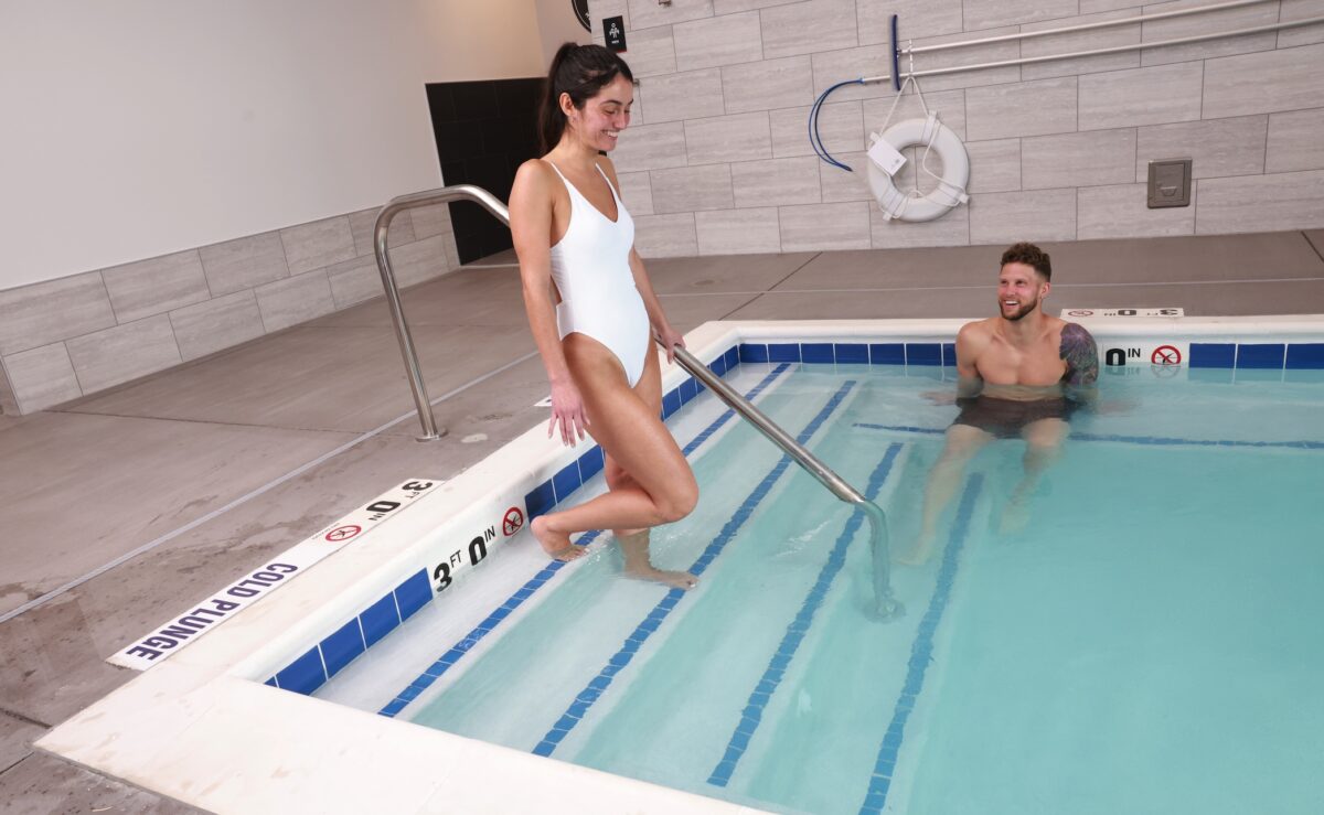 A woman walking into an indoor swimming pool