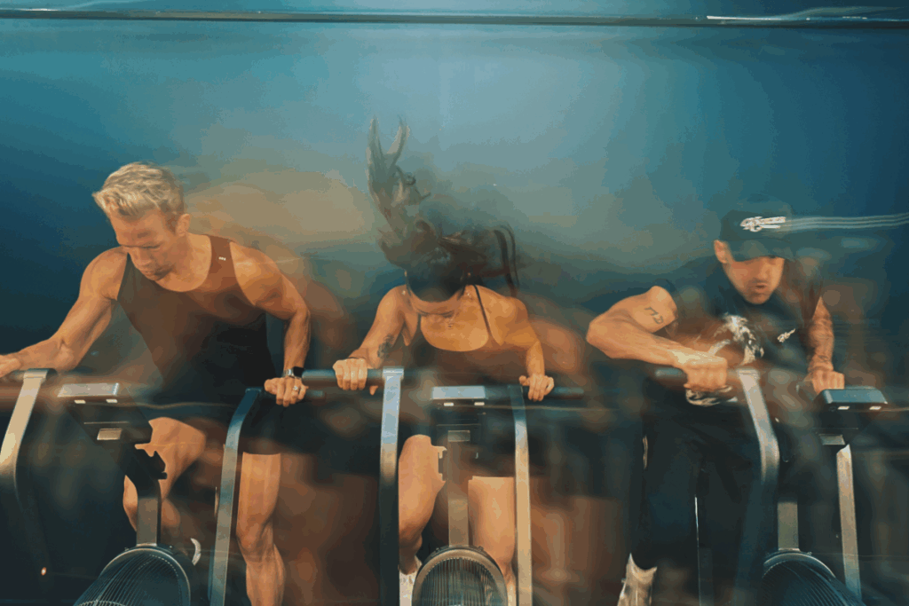 Three exercisers on stationary bikes