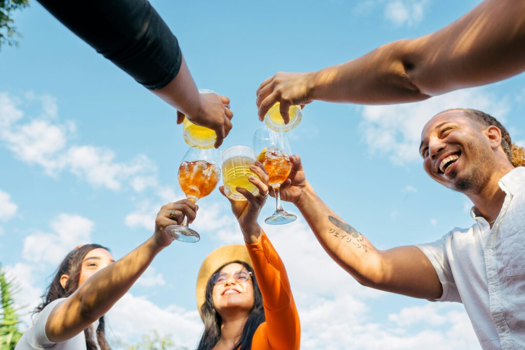 Group of friends toasting with colorful drinks