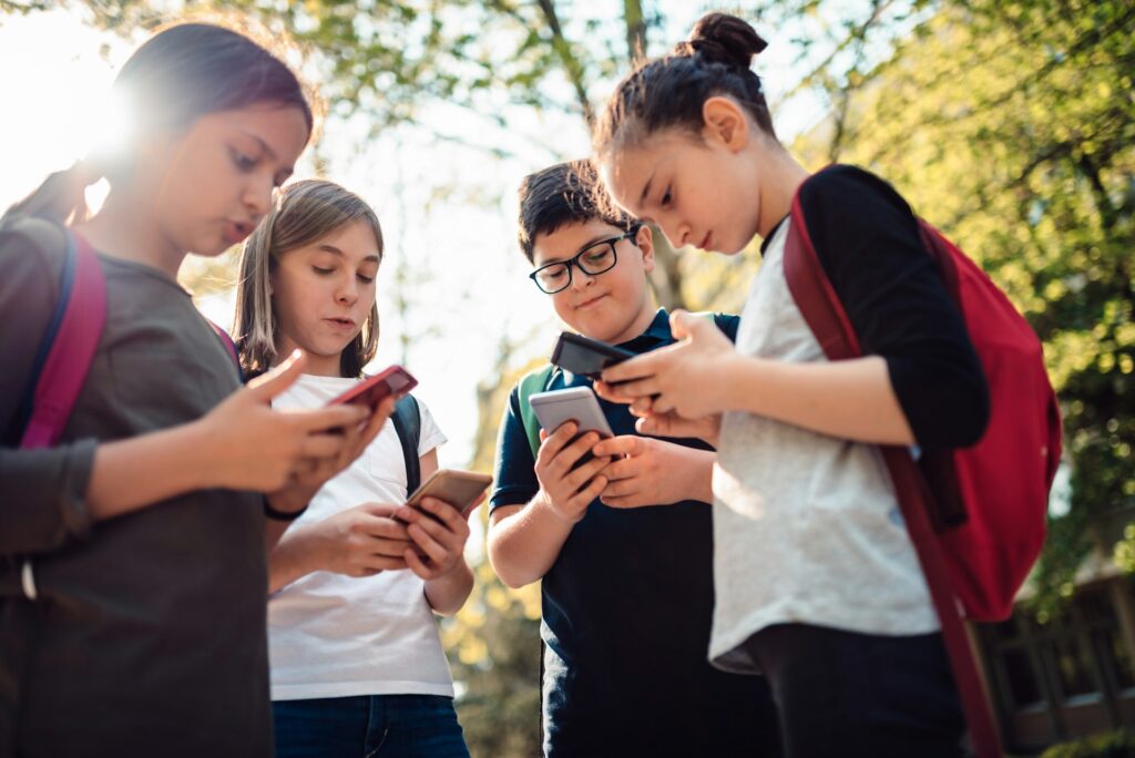 Group of schoolchildren on their cell phones
