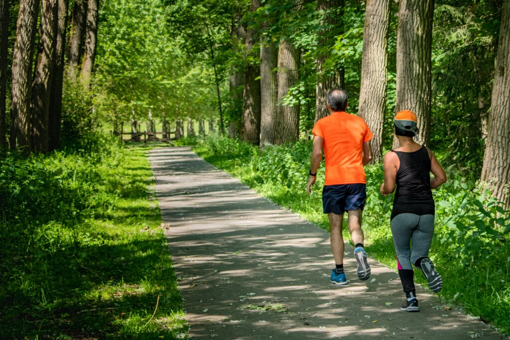 Two seniors running on an outdoor trail