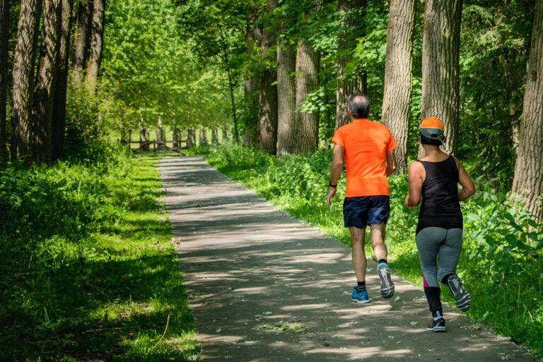 Two seniors running on an outdoor trail