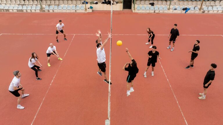 Adults playing volleyball on an outdoor court