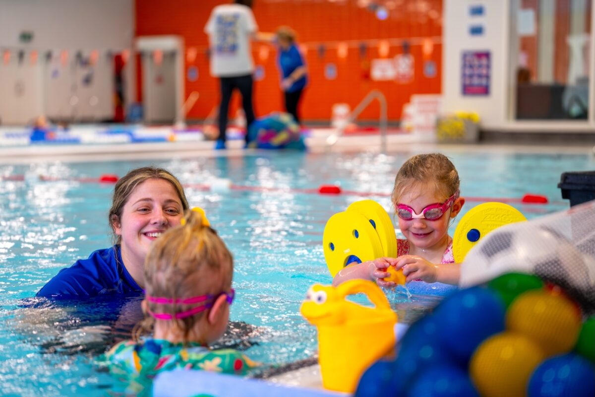 Woman and child swimming in an indoor pool