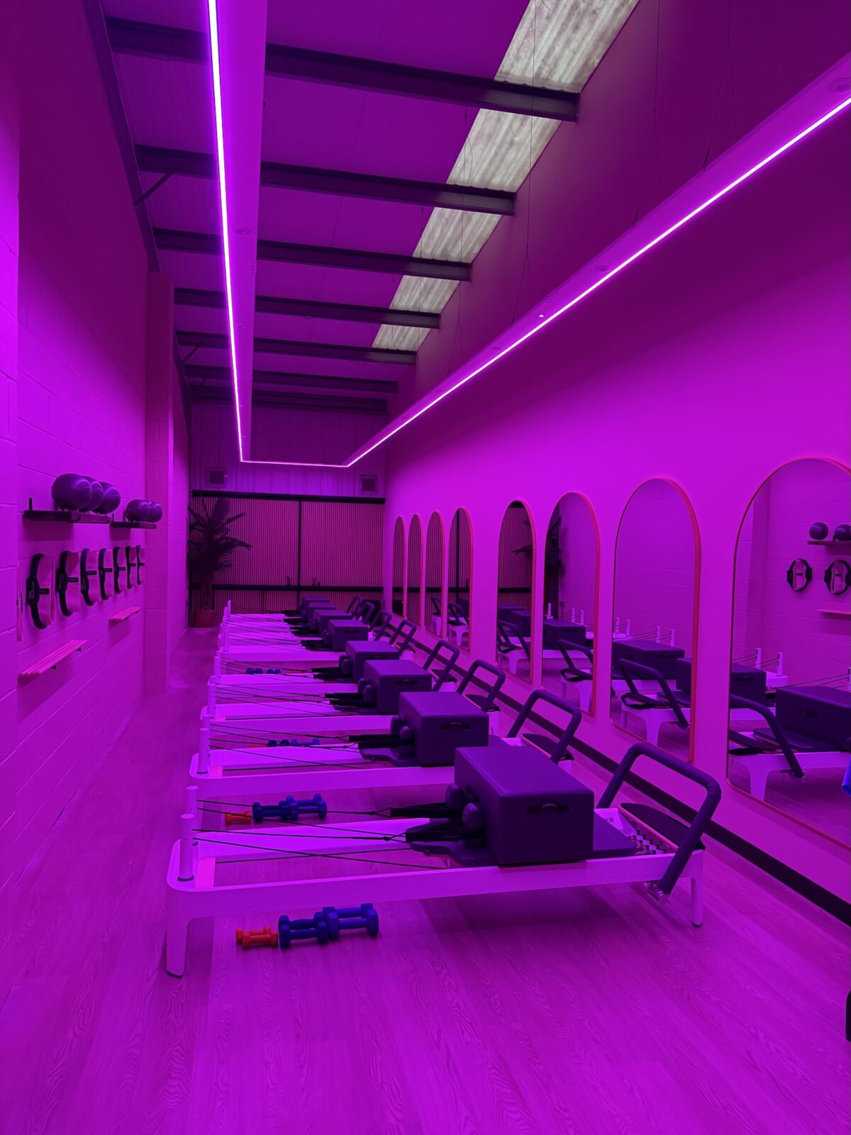 Purple-lit reformer Pilates room