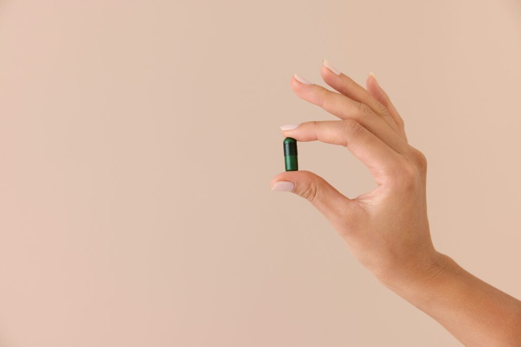 Person holding a green pill