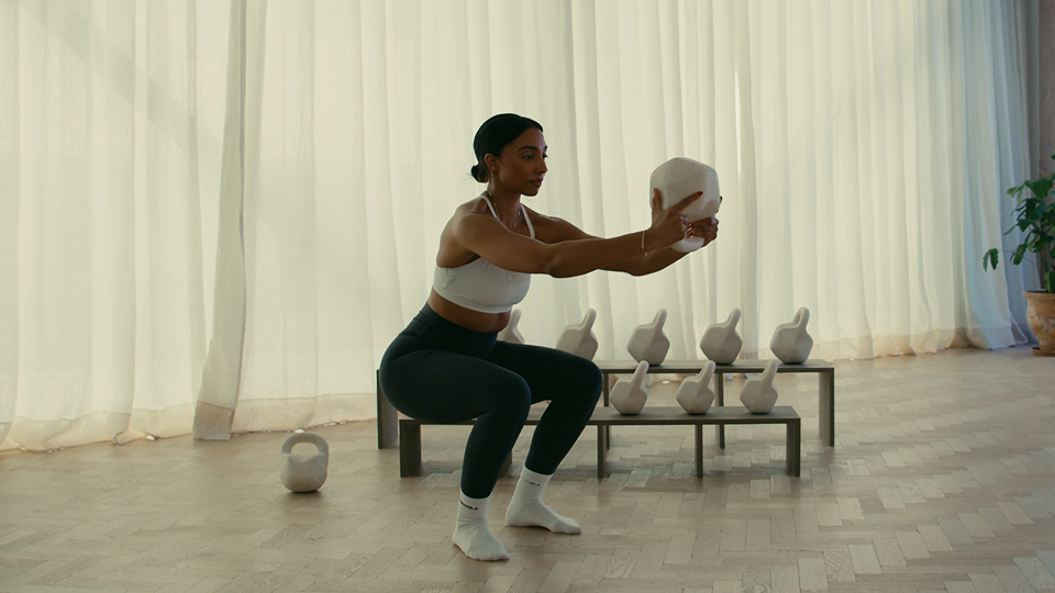 Woman performing a squat with a kettlebell