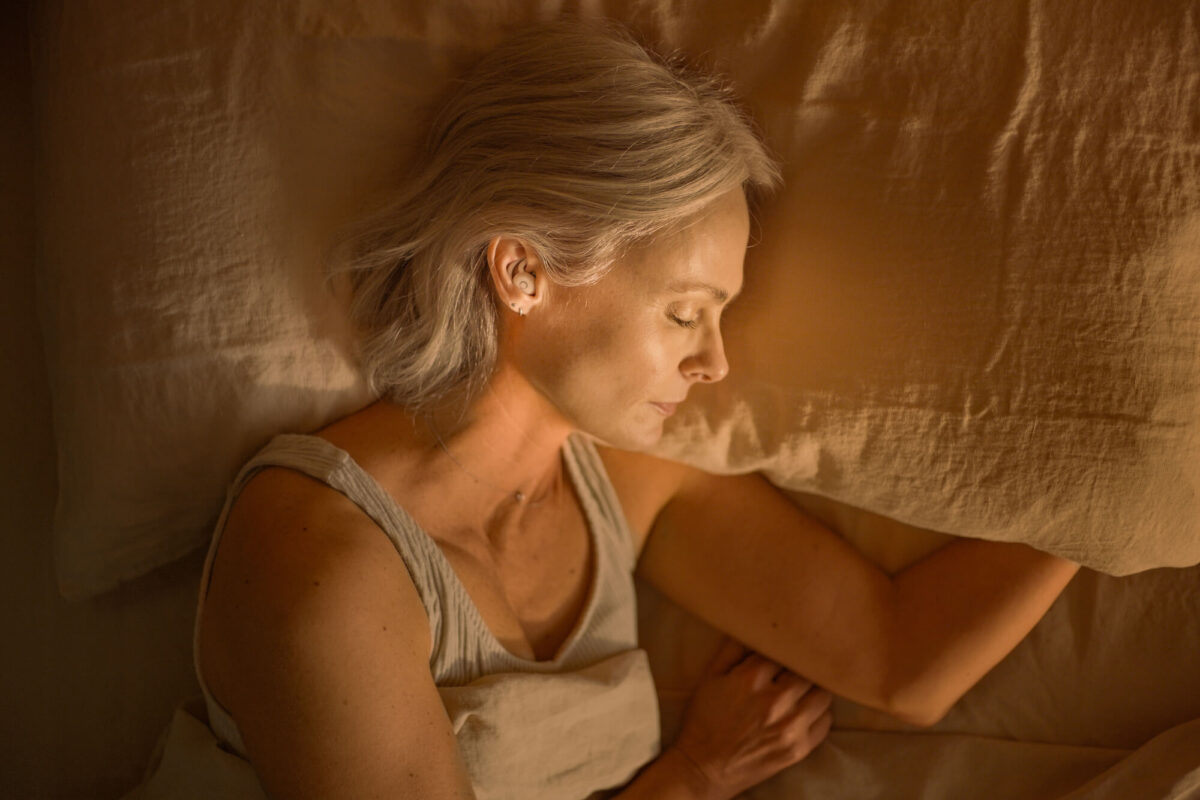 Woman sleeping Ozlo earbuds