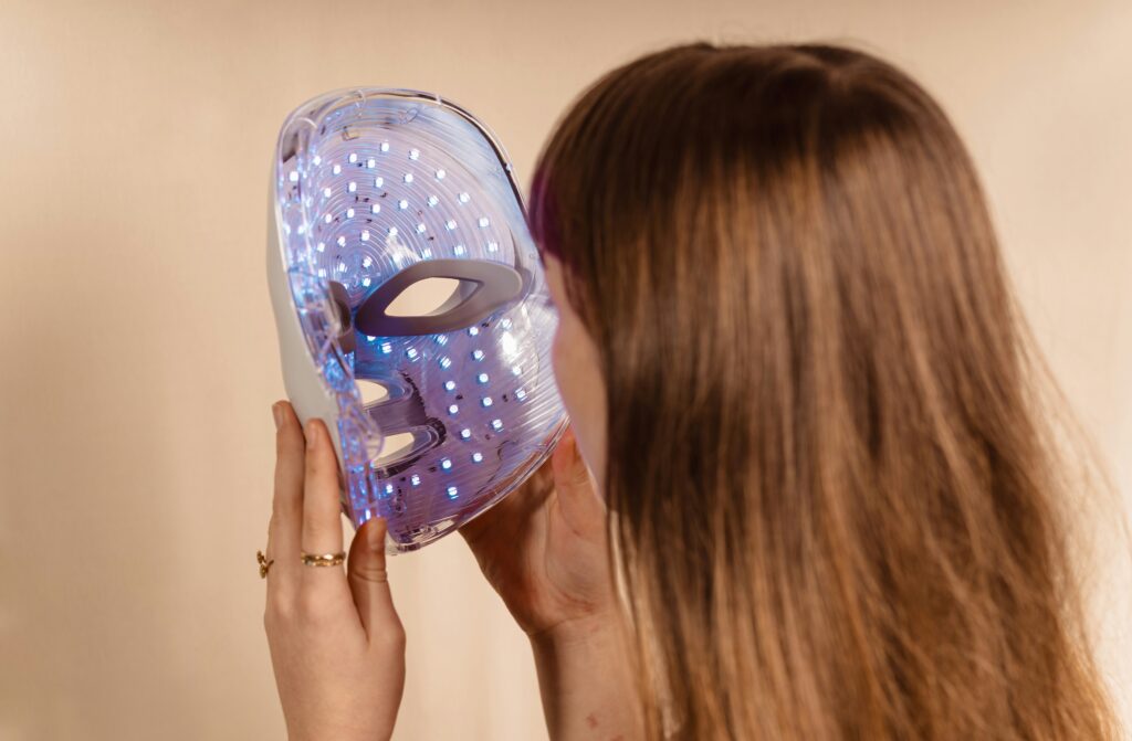 Woman putting on an LED face mask