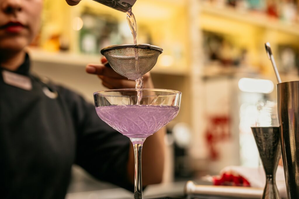 Pouring a light purple cocktail