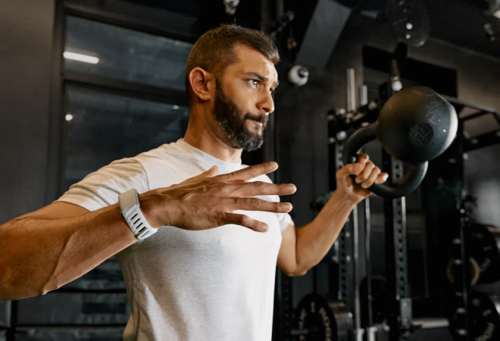 Man performing a kettlebell exercise at the gym