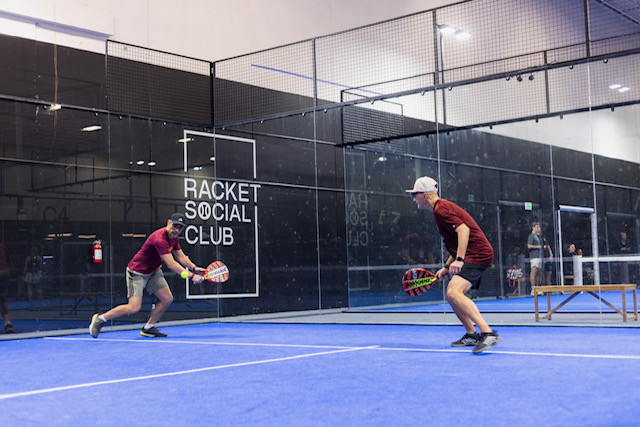 Two men playing a racquet sport indoors