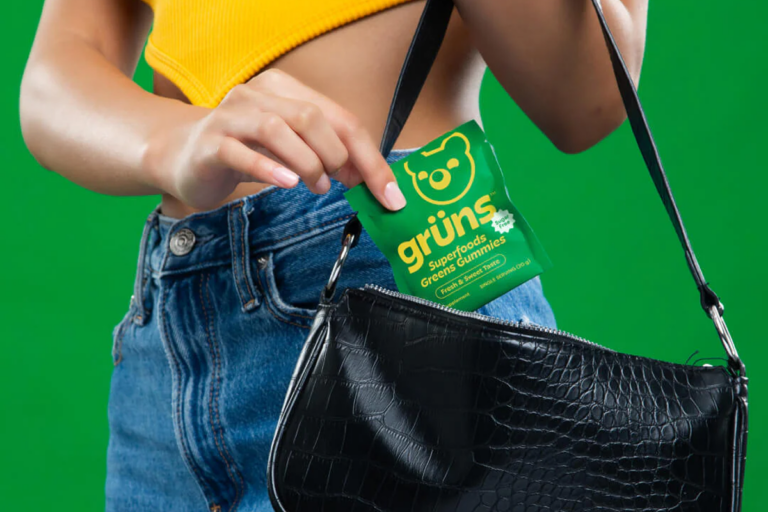 Woman placing a pack of Grüns gummies in her purse