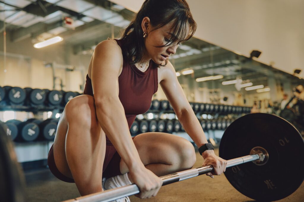 Woman wearing a WHOOP band and holding a barbell