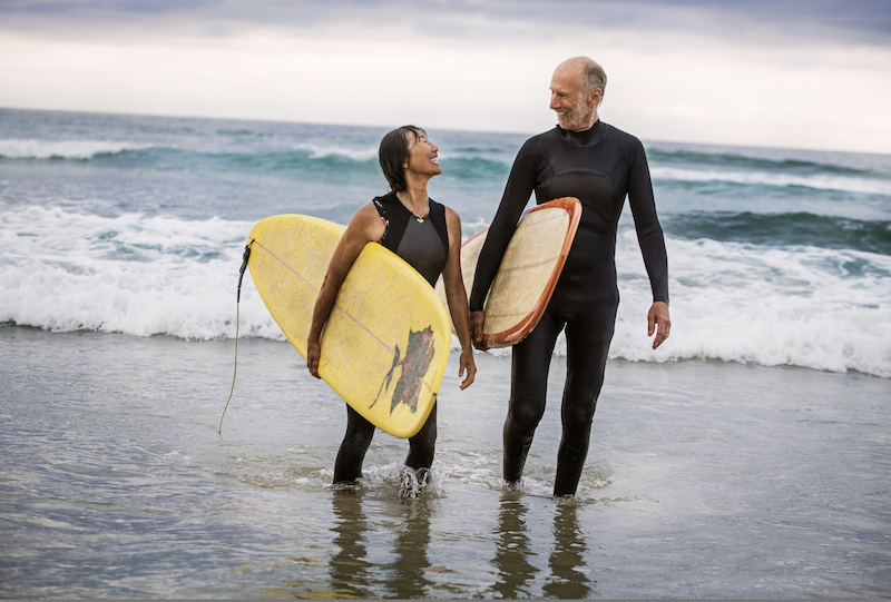 Older man and woman surfing