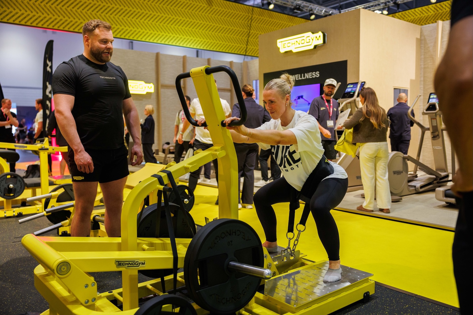 Woman performing a squat with a strength training machine