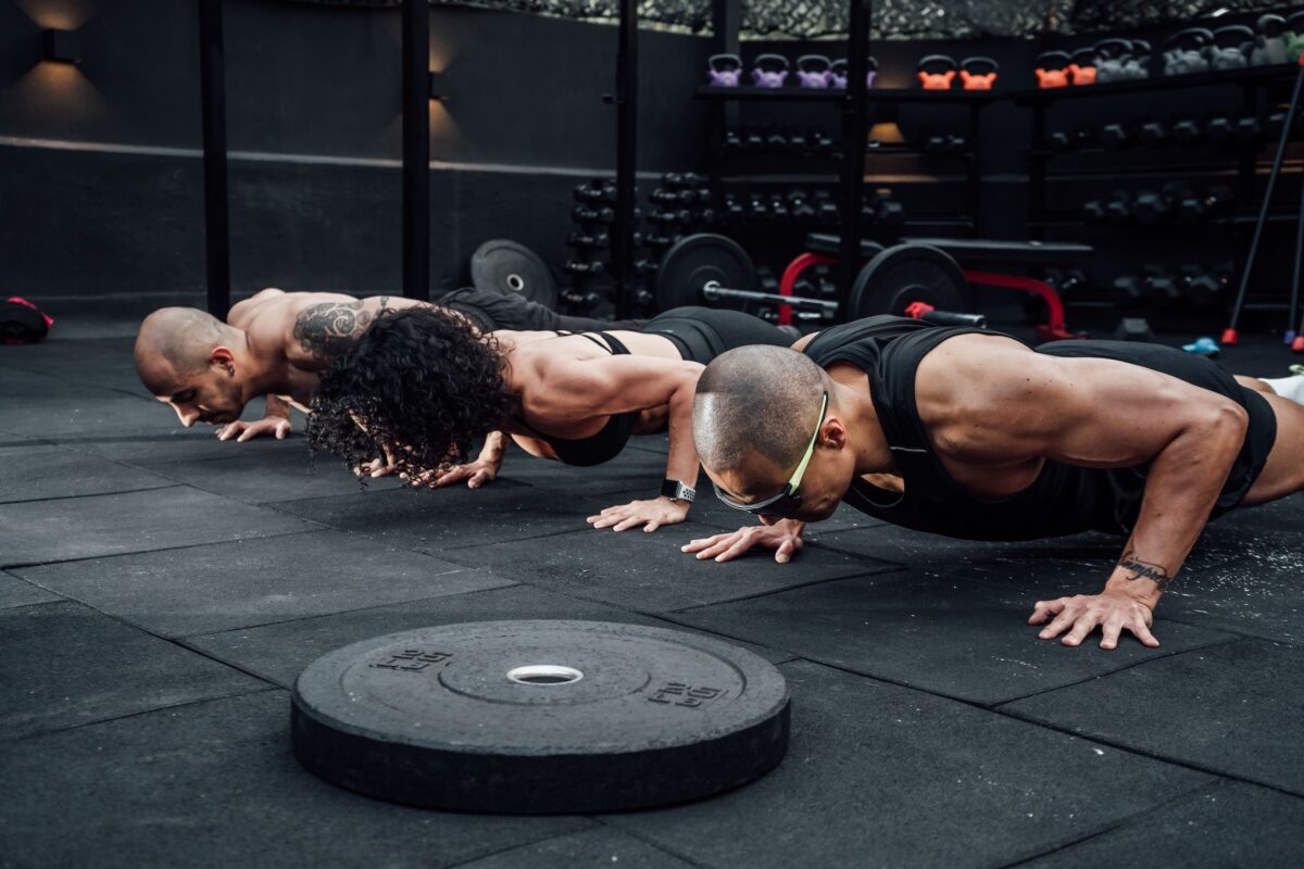 Row of people performing push ups at a gym