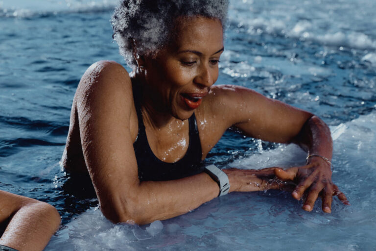 Elder woman wearing a WHOOP band in a pool