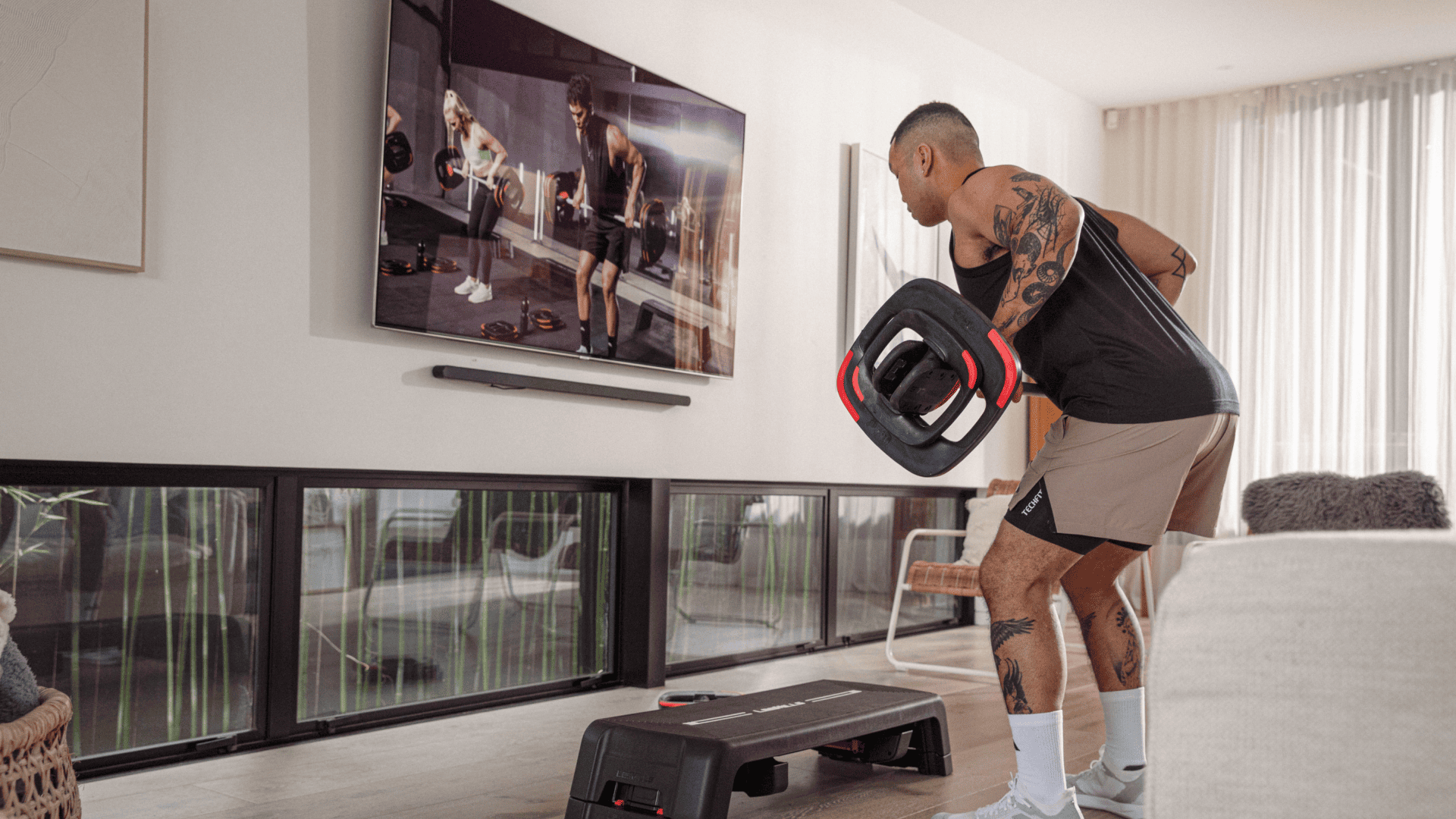 Athletic male sing LES MILLS strength programming at home