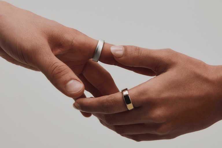 Two hands wearing Oura rings holding